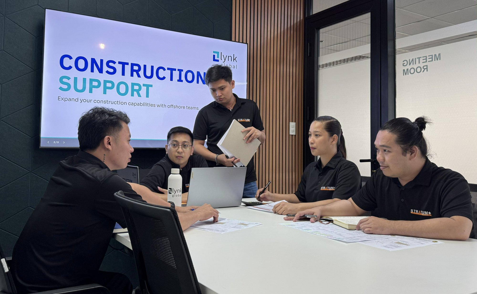 Construction offshore team members in a meeting room collaborating around a table. 